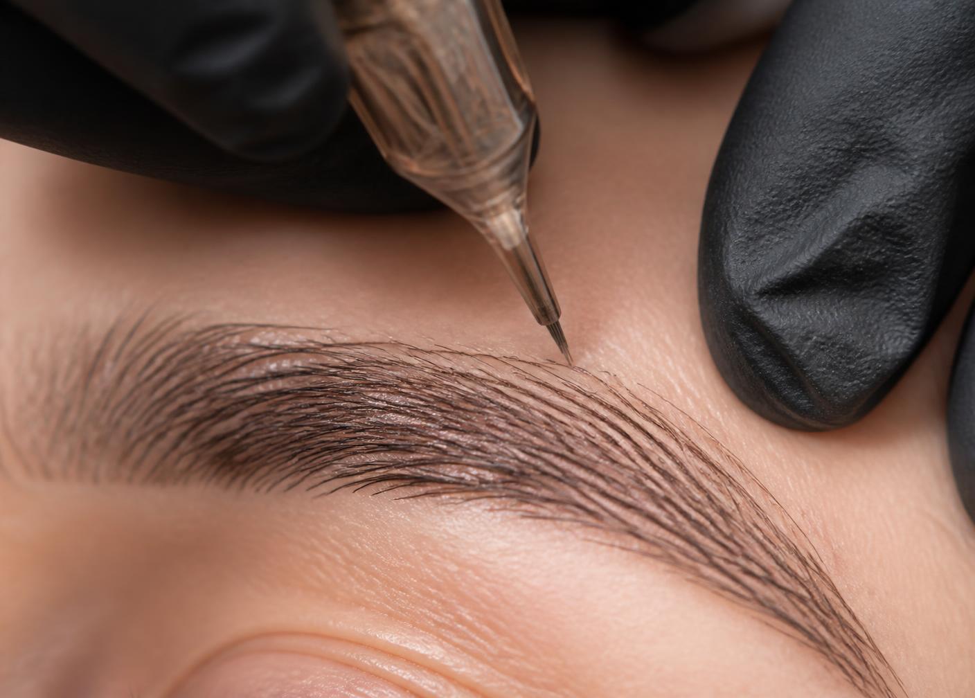 Close-up of a permanent makeup needle creating precise nano hairstrokes on an eyebrow